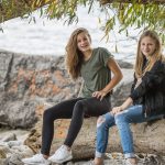 2-women-sitting-on-rock-during-daytime-214576