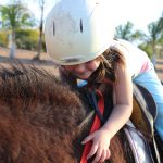 girl-in-blue-pants-riding-brown-animal-997474